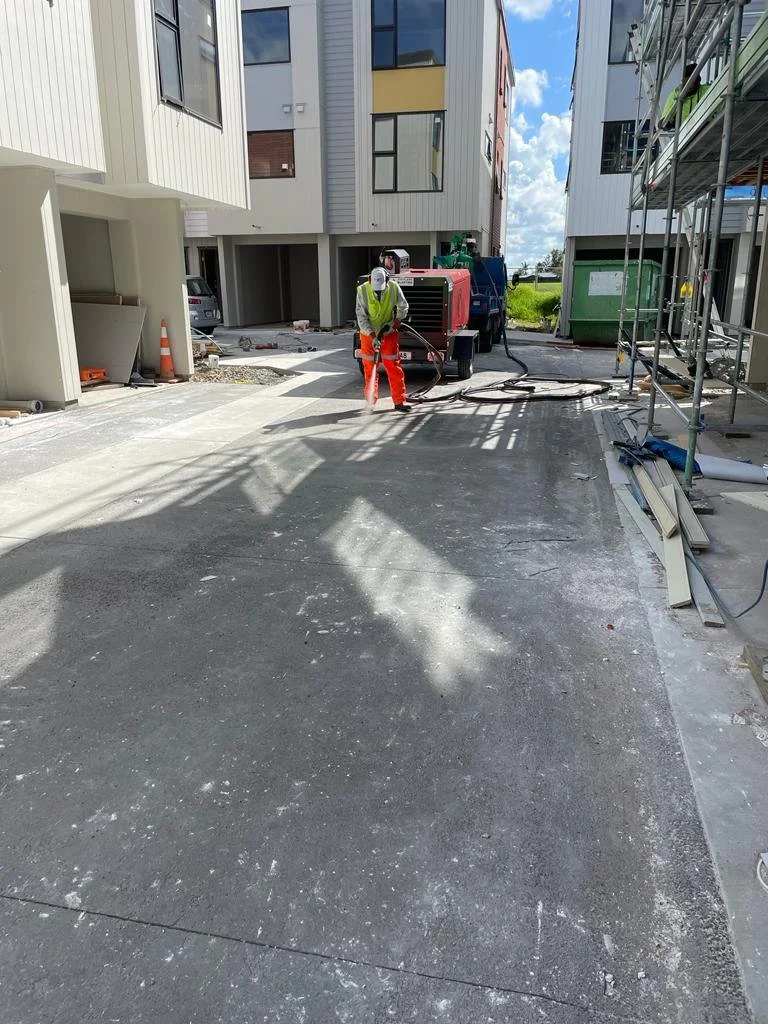 Auckland Blasting preparing a concrete courtyard beside new apartments.